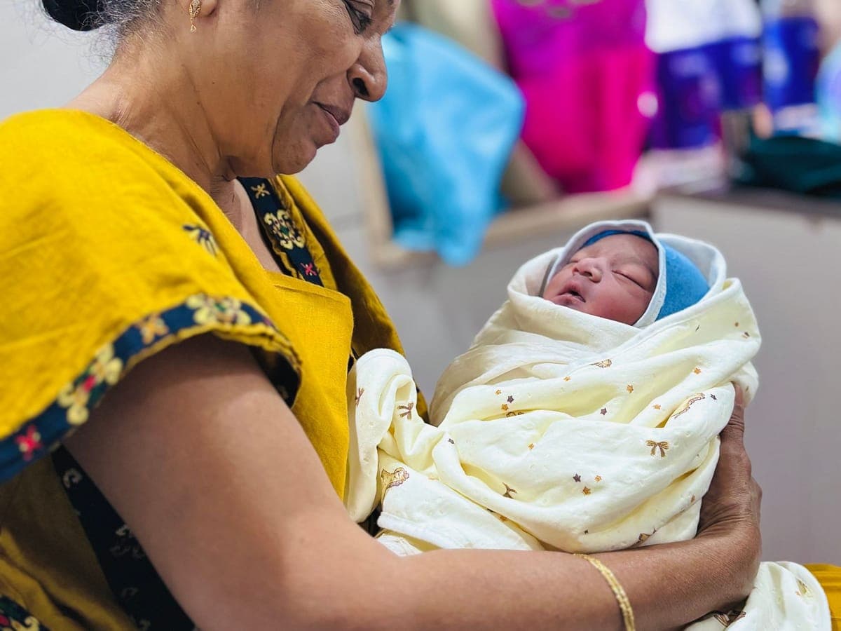 Grandmother holding a newborn baby wrapped in a blanket