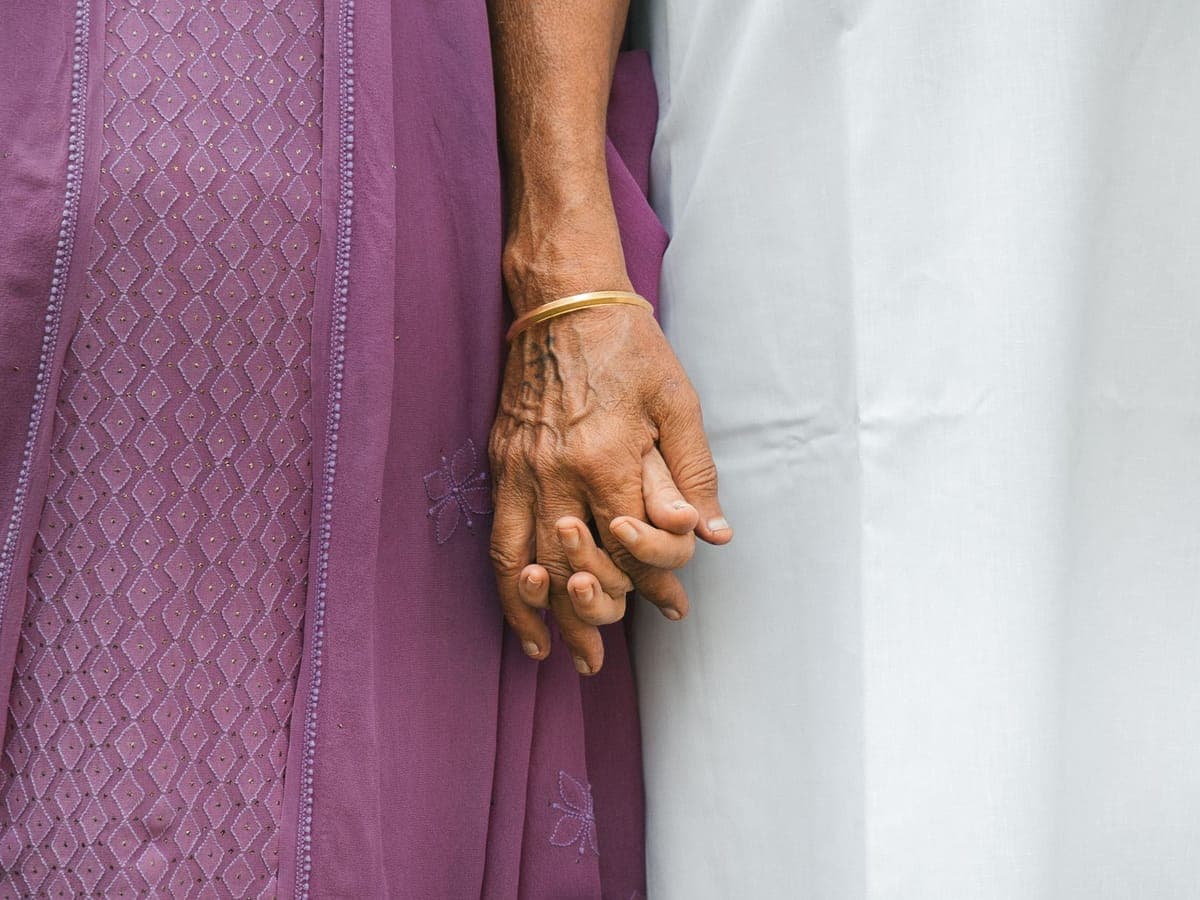 Elderly woman's hand held gently by a family member