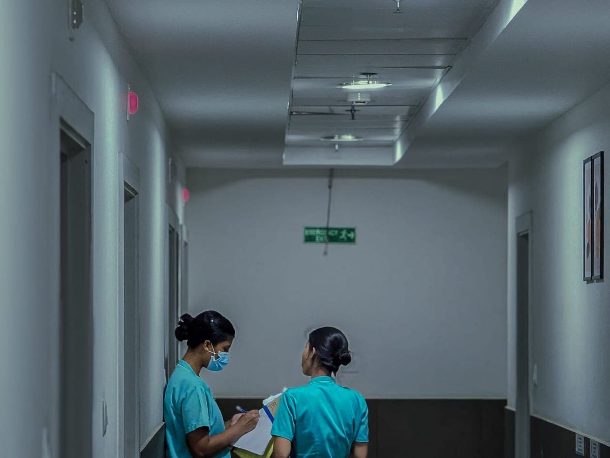 Two nurses talking in a hospital corridor