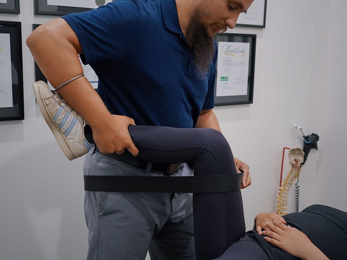 Physiotherapist guiding a leg-stretching exercise